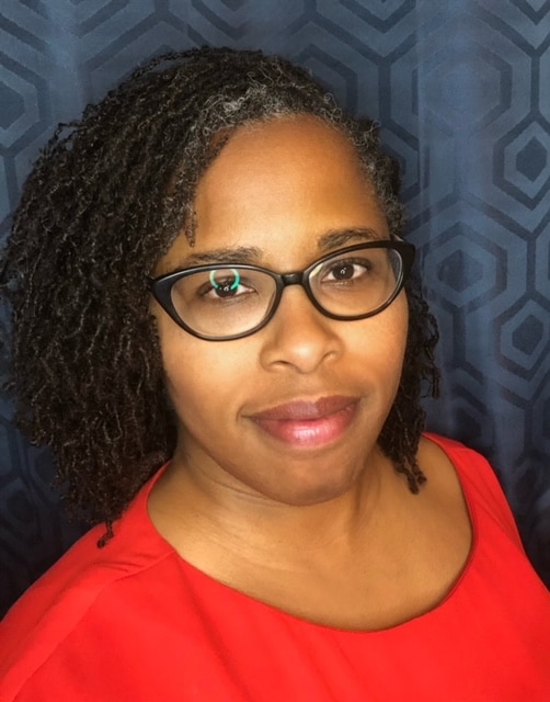 The Dementia Dietitian - Ayanna Smart is pictured smiling, against a dark blue background.